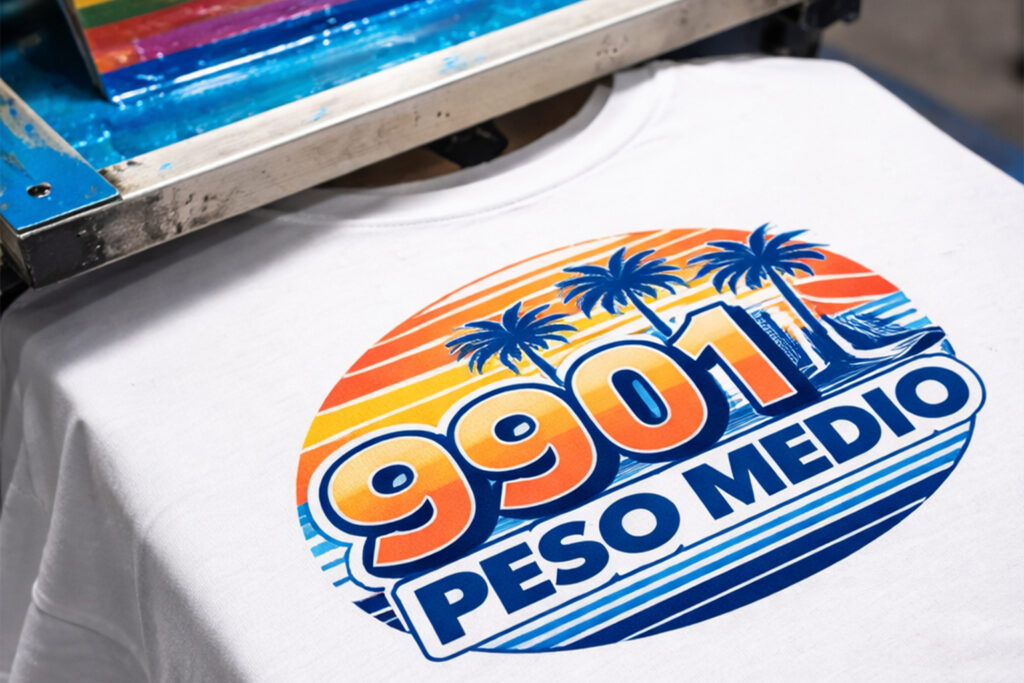 Playera 9901 peso medio blanca durante proceso de serigrafía, mostrando excelente absorción de tinta, definición de color y acabado uniforme.