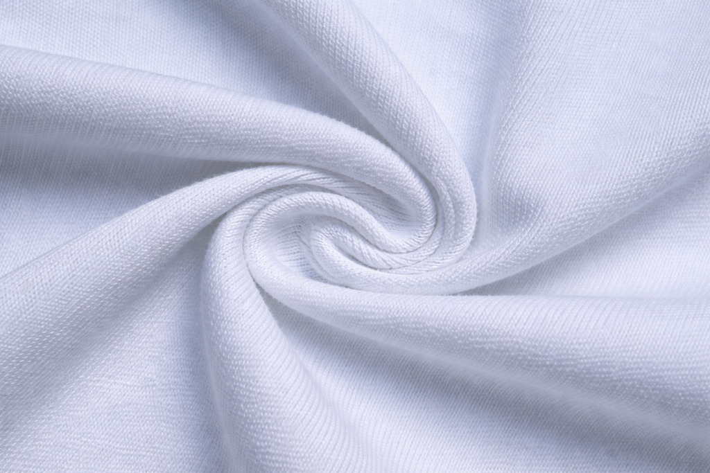 Detalle macro de tela blanca con textura tipo algodón peinado, pliegue en espiral y tejido uniforme